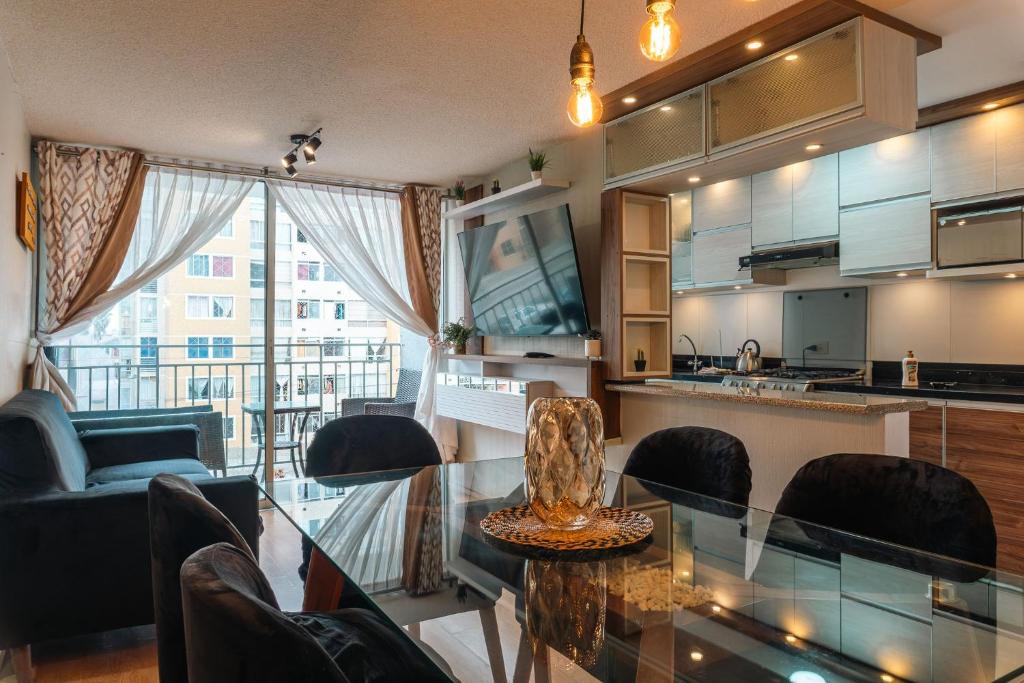 eine Küche und ein Wohnzimmer mit einem Glastisch und Stühlen in der Unterkunft Flat Equipado Callao Cerca al Aeropueto Jorge Chávez 2 Dormitorios in Lima