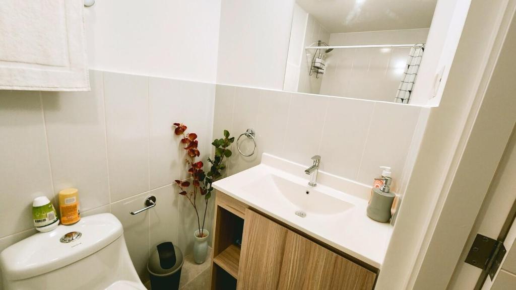 a bathroom with a sink and a toilet and a mirror at 5CERO2 STAYMENTS On Edificio Fiamene Zona 10 Guatemala in Estación Pamplona
