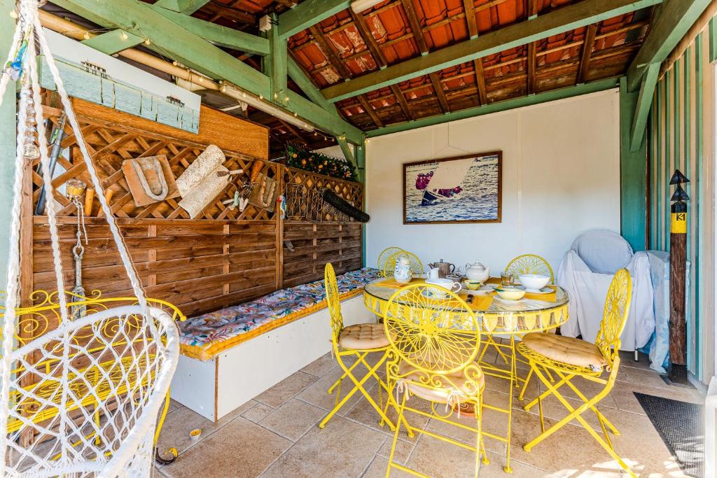a patio with a table and chairs and a hammock at La Chambre Curry du Bassin in La Teste-de-Buch
