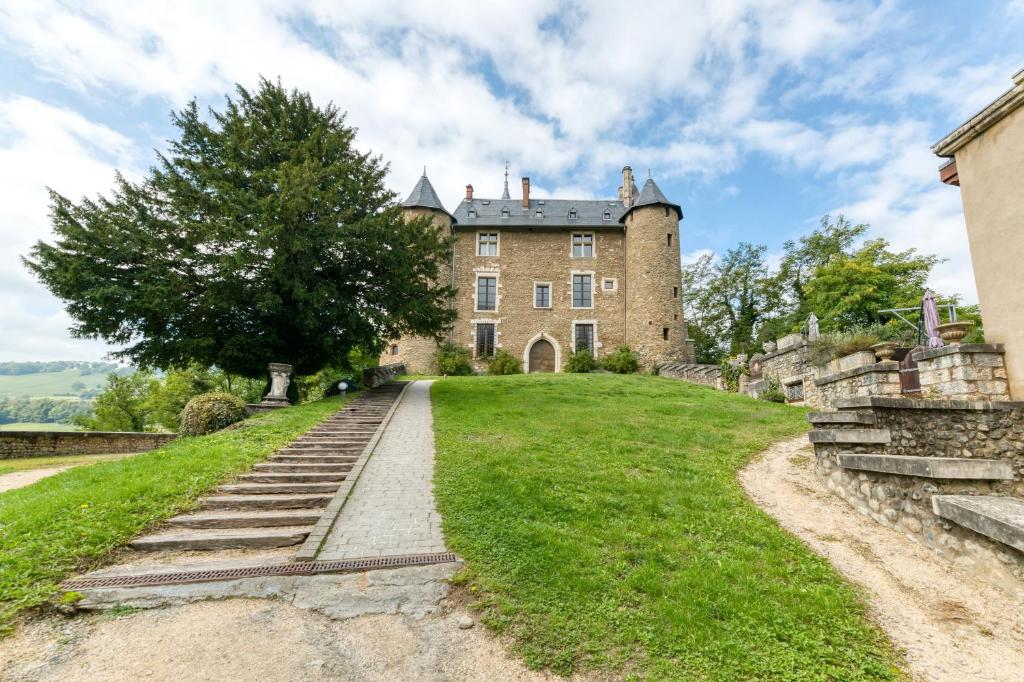 ein altes Schloss auf einem Grashügel in der Unterkunft Au Château d’Uriage-Chamrousse in Uriage-les-Bains