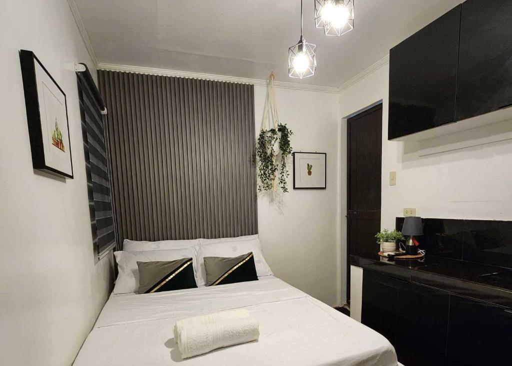ein Schlafzimmer mit einem großen weißen Bett in einem Zimmer in der Unterkunft T&A Building in Manila