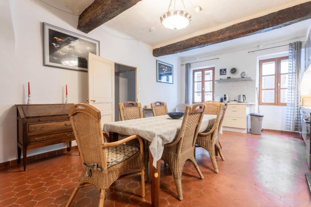 een eetkamer met een tafel en stoelen en een piano bij Maison Collo in Collobrières
