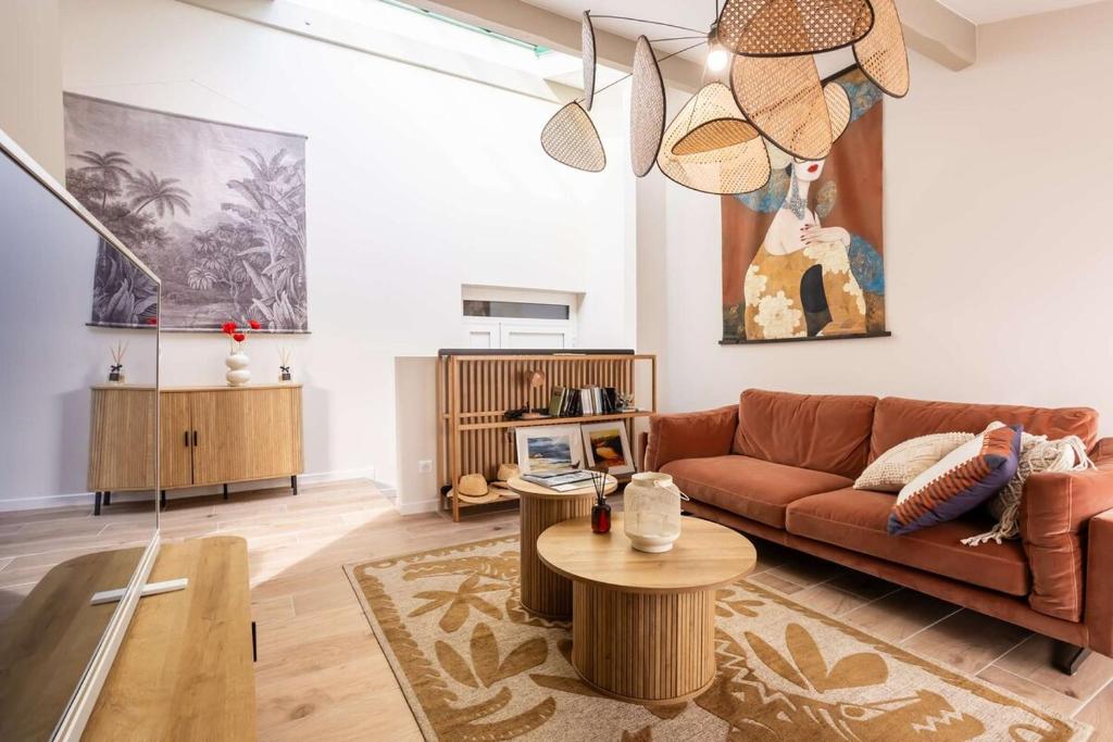 a living room with a brown couch and a table at Magnifique Appartement Biscarrosse Bourg in Biscarrosse