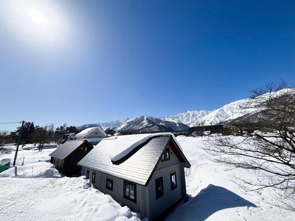 白馬村にあるel green logの山々を背景に雪に覆われた家
