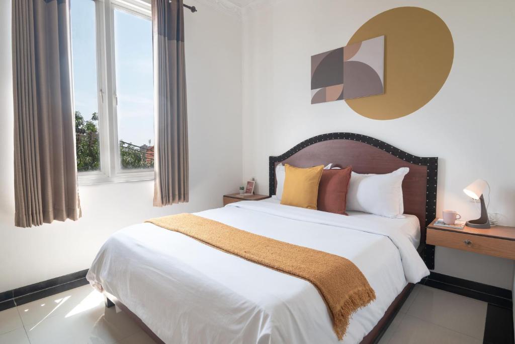 a bedroom with a large bed with white sheets and pillows at Cove Zeidan House in Gabung