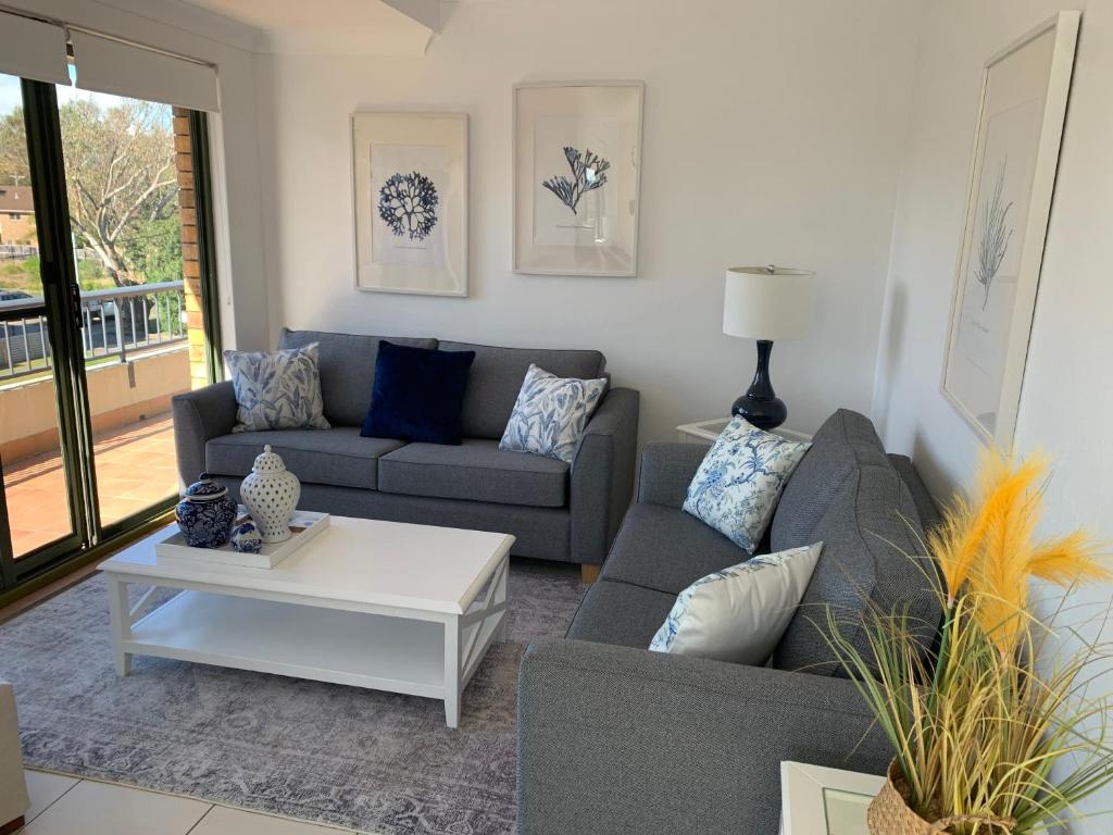 a living room with two couches and a coffee table at Beautiful and Bright Penthouse in Hawks Nest
