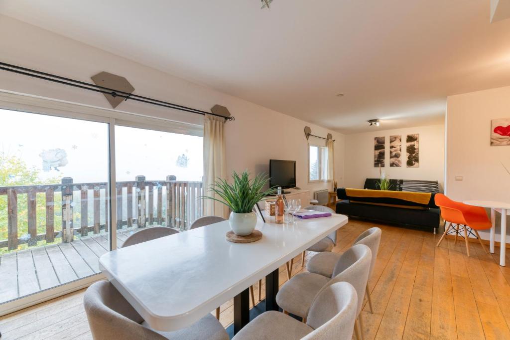 ein Wohnzimmer mit Tisch und Stühlen in der Unterkunft Vacances de rêves - Gaboureaux in Chamrousse