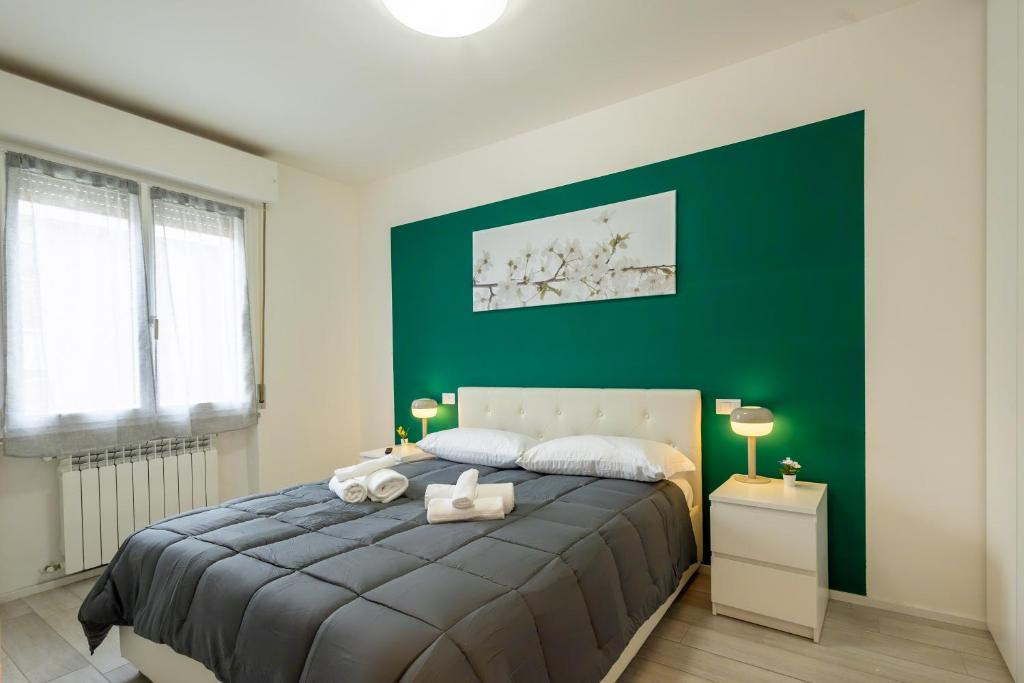 a bedroom with a large bed with a green wall at Casa Maritè - Private Parking in Pisa