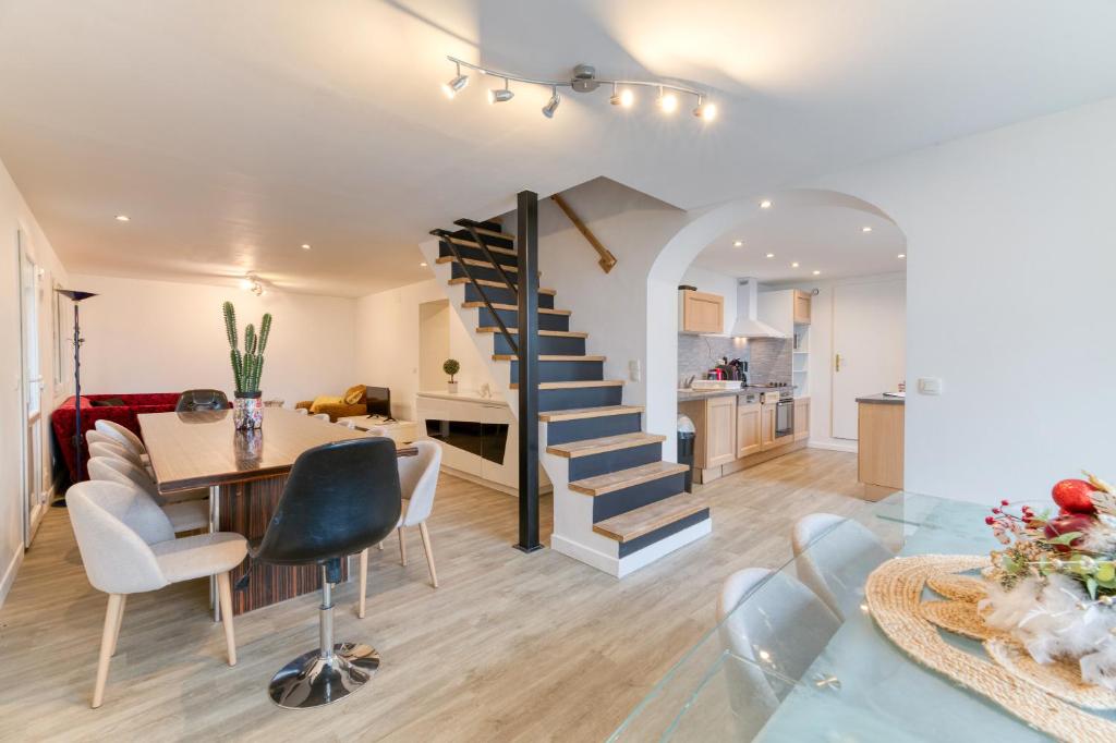 a living room and dining room with a spiral staircase at Vacances de rêves - Casserousse in Chamrousse