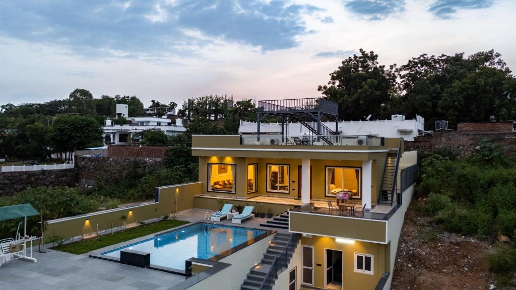 a house with a swimming pool on top of it at ELIVAAS LakeMount 2-BHK Getaway with Private Pool, Open-Air Gazebo & Terrace At Fatehsagar Lake in Udaipur