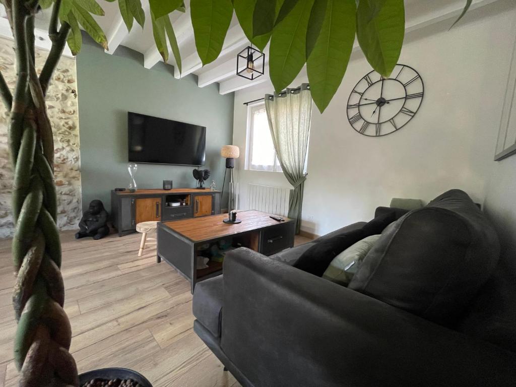 a living room with a couch and a table at Maison du bonheur in Combres