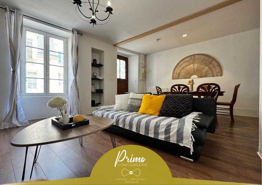 ein Wohnzimmer mit Sofa und Tisch in der Unterkunft Maison Hythou de ville 6 personnes in Thouars