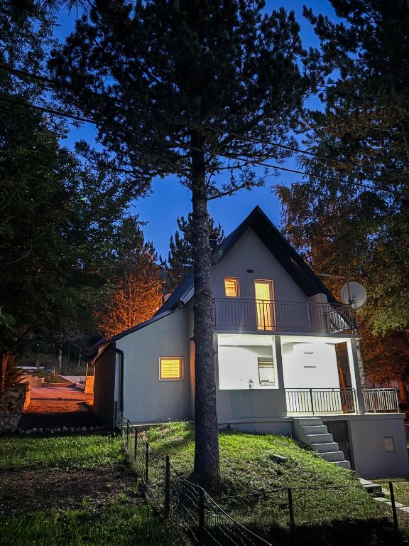 a house with a tree in front of it at Pineta Blidinje in Blidinje