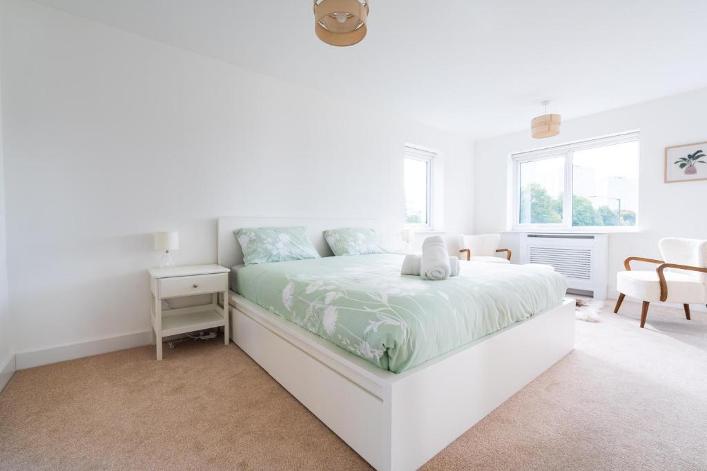 a white bedroom with a bed and a window at 4-bedroom New House Near City Centre in Manchester
