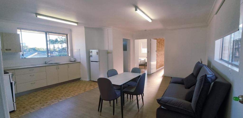 Una cocina y un comedor con mesa y sillas. en Park Beach Plaza Apartment, en Coffs Harbour