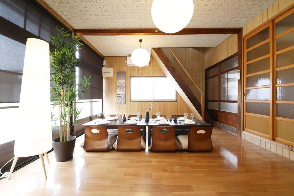 una grande stanza con tavolo e alcune sedie di Kiryucho House a Takayama