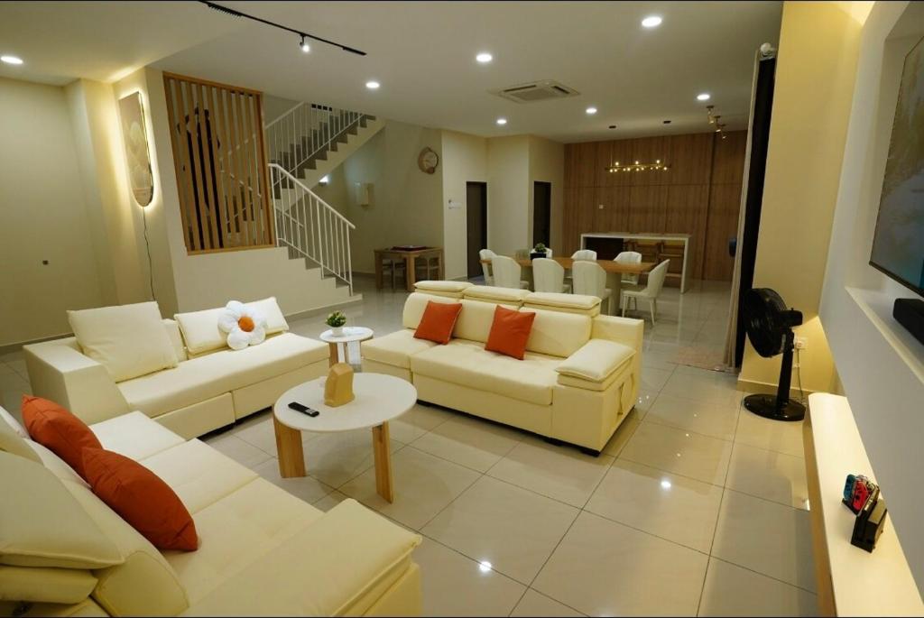 a living room with white couches and a table at Desaru 918 Muji Villa in Bandar Penawar