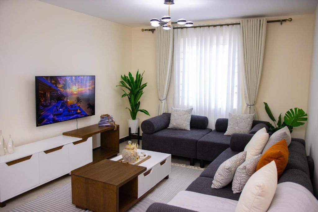 a living room with a couch and a tv at K&K Stays in Nakuru