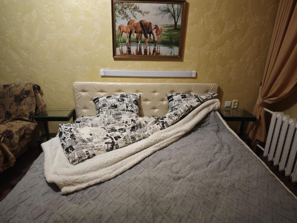 a bed with a blanket and pillows on it at Квартира 1 комнатная in Aktau