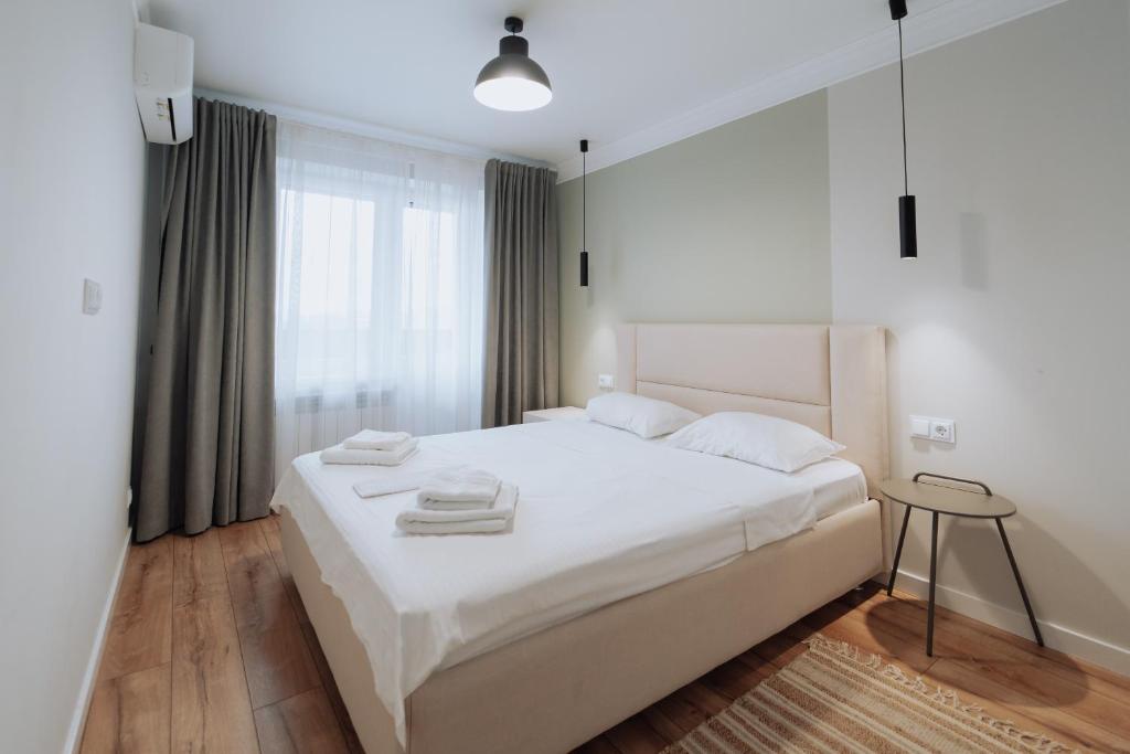 Una cama o camas en una habitación de NEW City Center, 2BR Shops, Buses & Cafés
