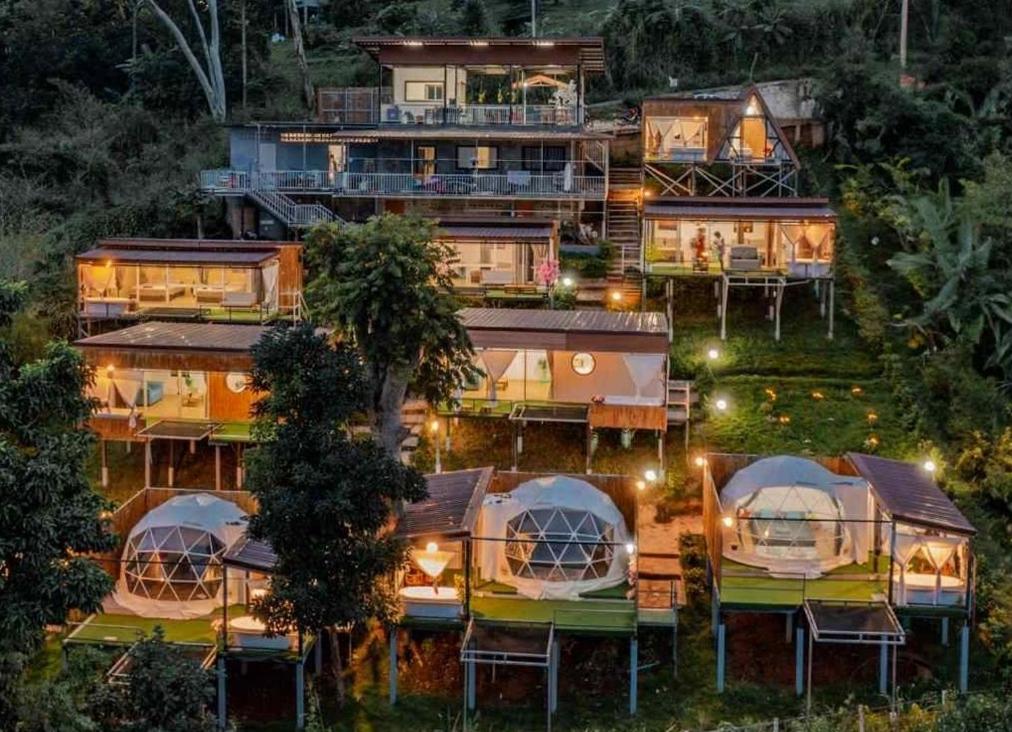 an aerial view of a group of yurt homes at night at ภูแสงไฟโฮมสเตย์ in Ban Tai