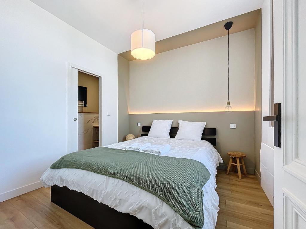 a bedroom with a large bed with a green blanket at Emeraude vue mer MALO LES BAINS in Dunkerque