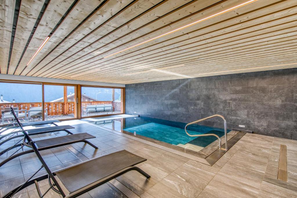 a swimming pool in a house with a ceiling at Apartment w pool and spa in Champéry
