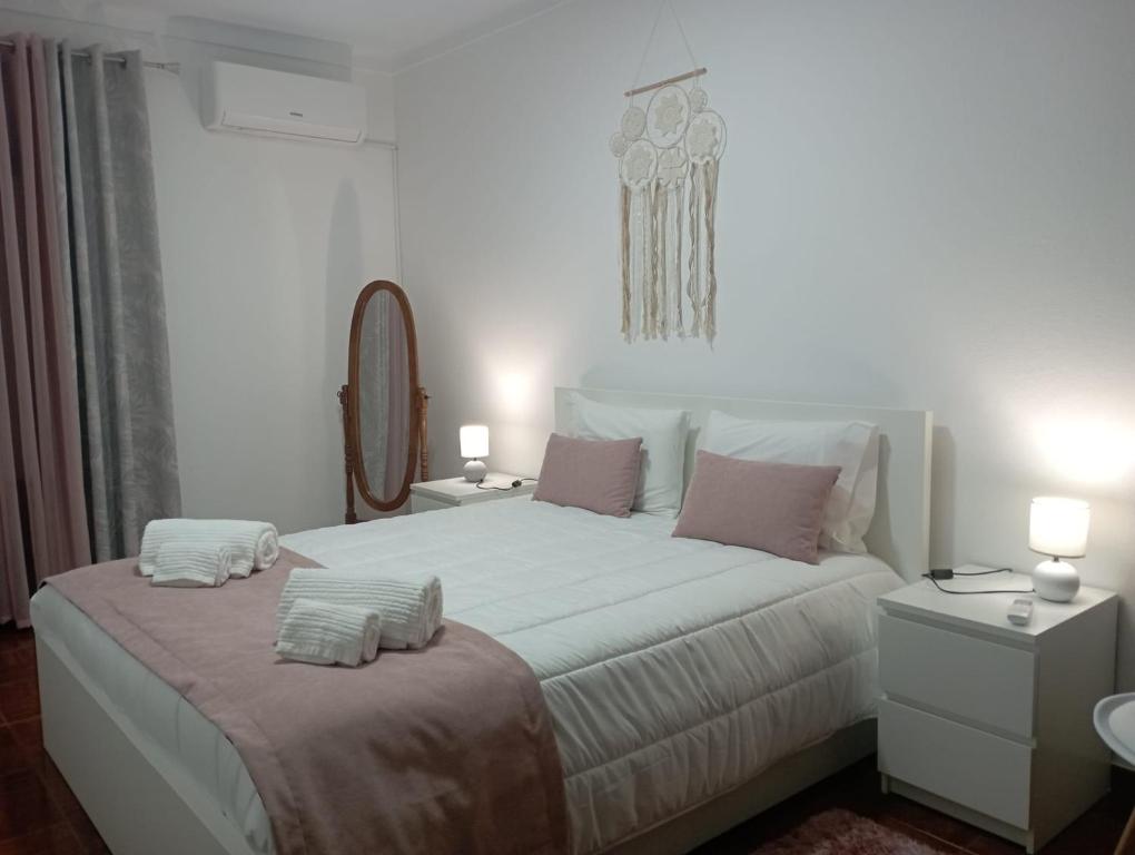 ein weißes Schlafzimmer mit einem großen Bett mit zwei Kissen in der Unterkunft As Irmãs in Reguengos de Monsaraz