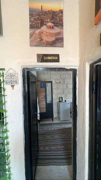 a doorway into a building with a sign on the wall at Mareda house in Midyat