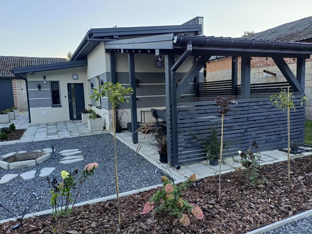 a garden with a pergola in front of a house at Domek pod lasem in Karmanowice
