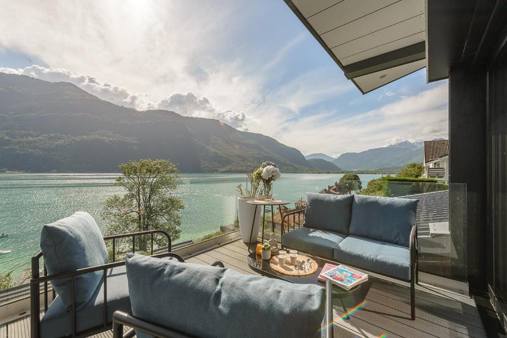einen Balkon mit Stühlen und Seeblick in der Unterkunft Le Cristal - Prestigieux appartement au Lac d'Annecy in Doussard