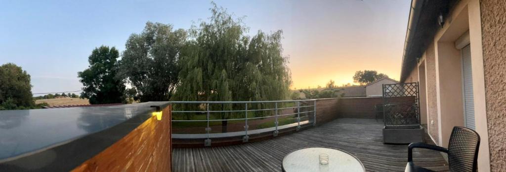 balkon ze stołem i krzesłami na tarasie w obiekcie Domaine de Jarentin - Loire 42 w mieście Saint-Marcel-de-Félines
