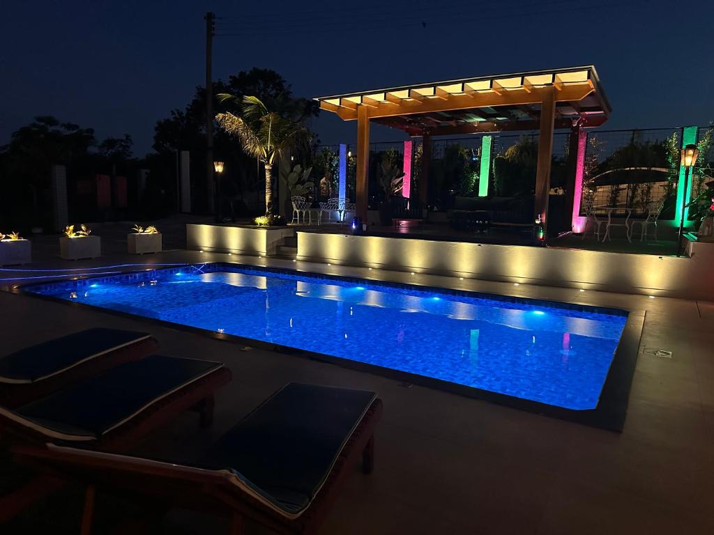 a swimming pool at night with a gazebo at Rancho Recanto dos Pássaros in Limeira