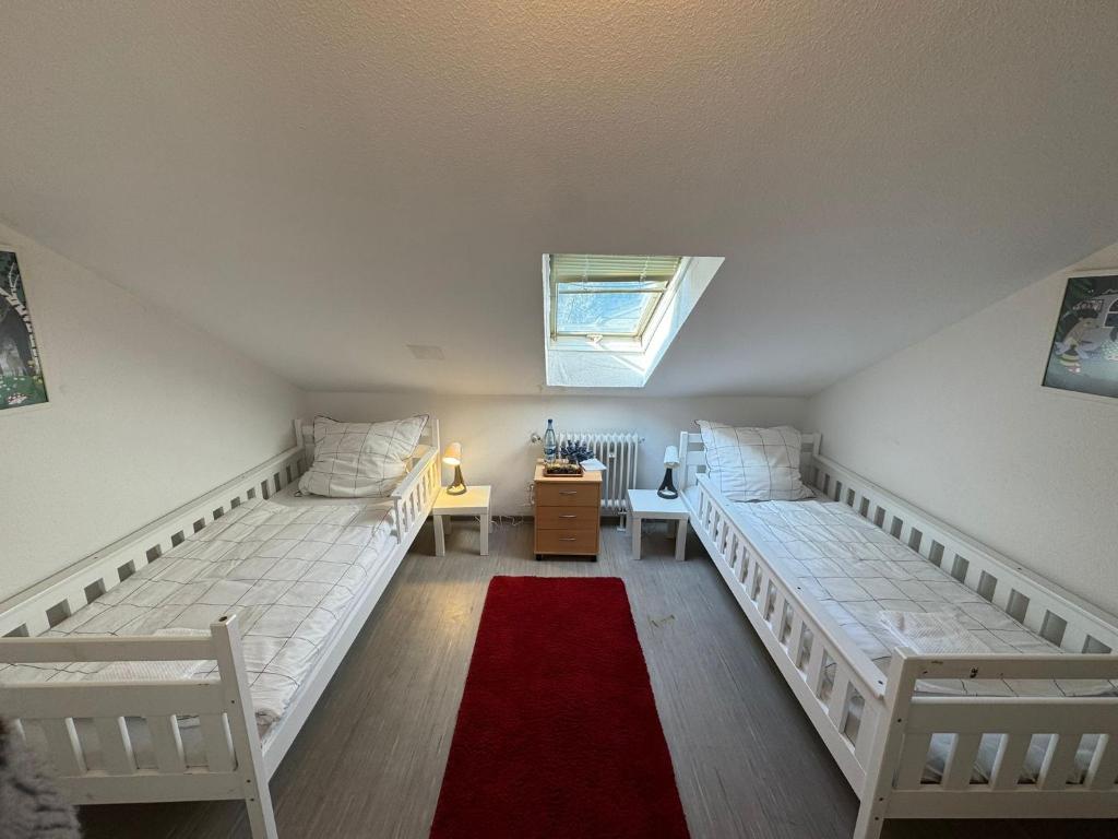 Zimmer im Dachgeschoss mit 2 Betten und einem Fenster in der Unterkunft Helles Privatzimmer mit Gemeinschaftsküche und-bad in Hannover