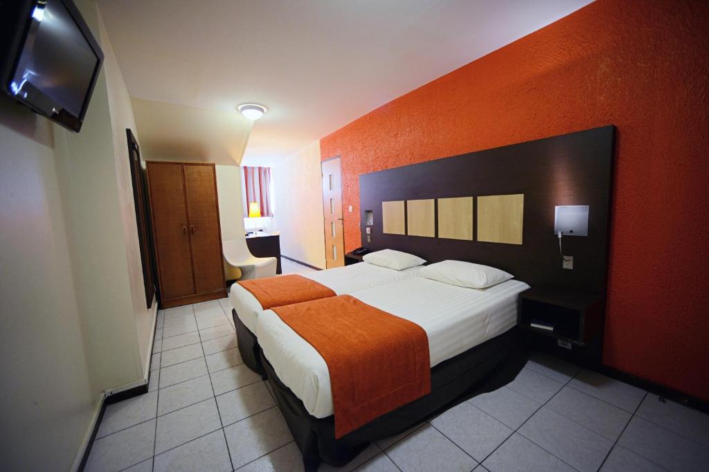 Postel nebo postele na pokoji v ubytování Central Hotel Cayenne