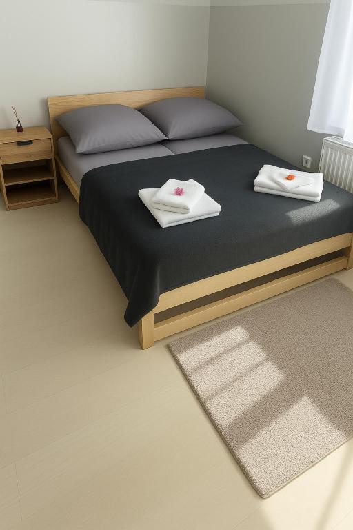 a bedroom with a bed with two towels on it at Hostel nad Drwęcą in Nowe Miasto Lubawskie