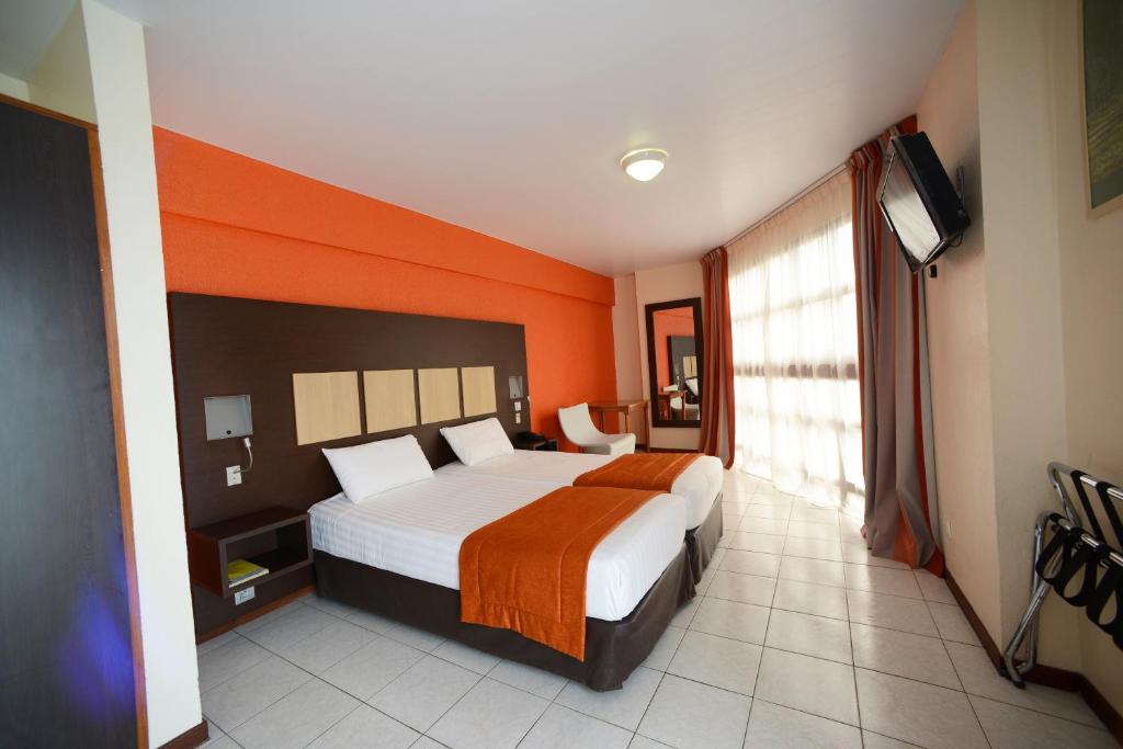 Postel nebo postele na pokoji v ubytování Central Hotel Cayenne