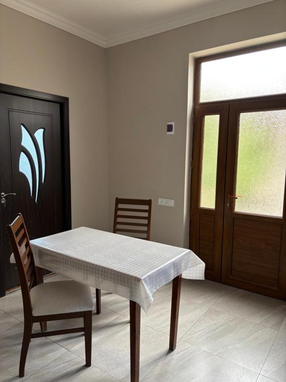 a dining room with a table and chairs and a door at Gyumri Home in Gyumri