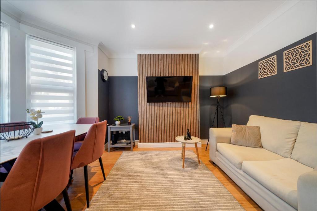 a living room with a white couch and a table at Stylish 5BR Bedford Home, Sleeps 7,Perfect for Contractors Deal, Near Transport in Bedford