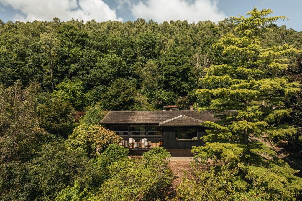 a house in the woods with trees at The Hideaway at Yew Trees, Ullswater in Watermillock