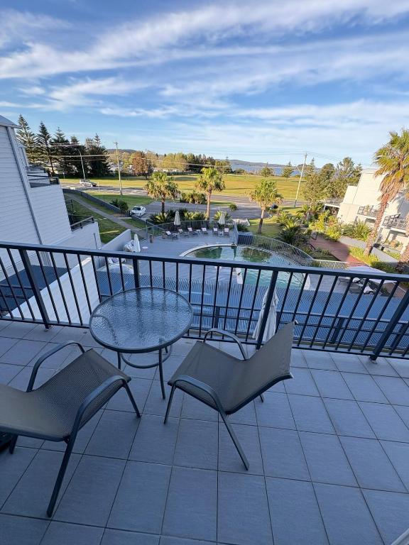 Un balcón con una mesa, sillas y una fuente. en Batemans Bay Getaway, en Batehaven