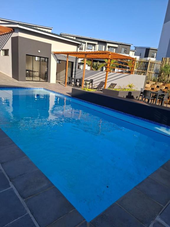 a large blue swimming pool in front of a building at Bliss Ballito Apartment in Ballito