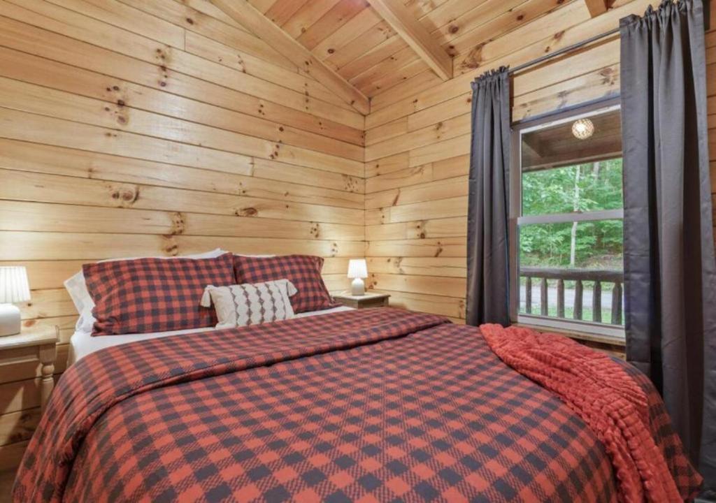 a bedroom with a bed in a log cabin at Copperhead Cabin- Hocking Hills Hot Tub Games in Logan