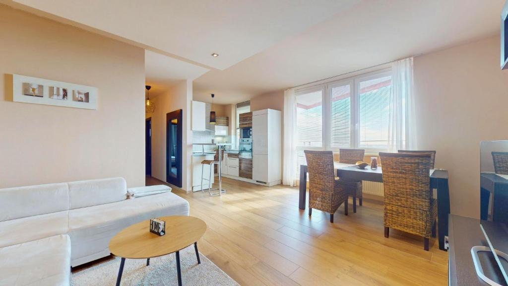 Una sala de estar con un sofá blanco y una mesa. en Koloseo apartman, en Bratislava