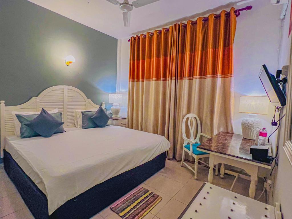 a bedroom with a bed and a desk with a computer at Oasis Ayurveda Resort Wadduwa in Wadduwa