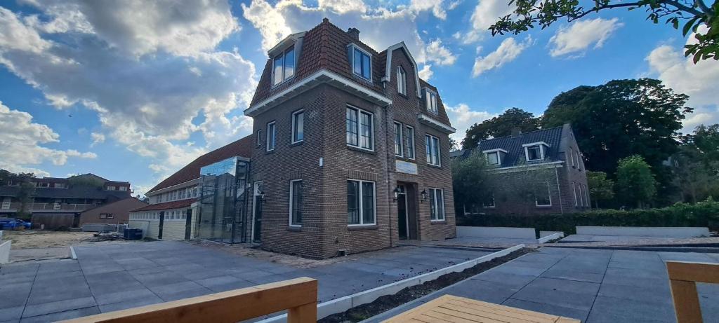 a large brick building with a tower on top at Boetiekhotel Het Gezellenhuis in Ouderkerk aan de Amstel