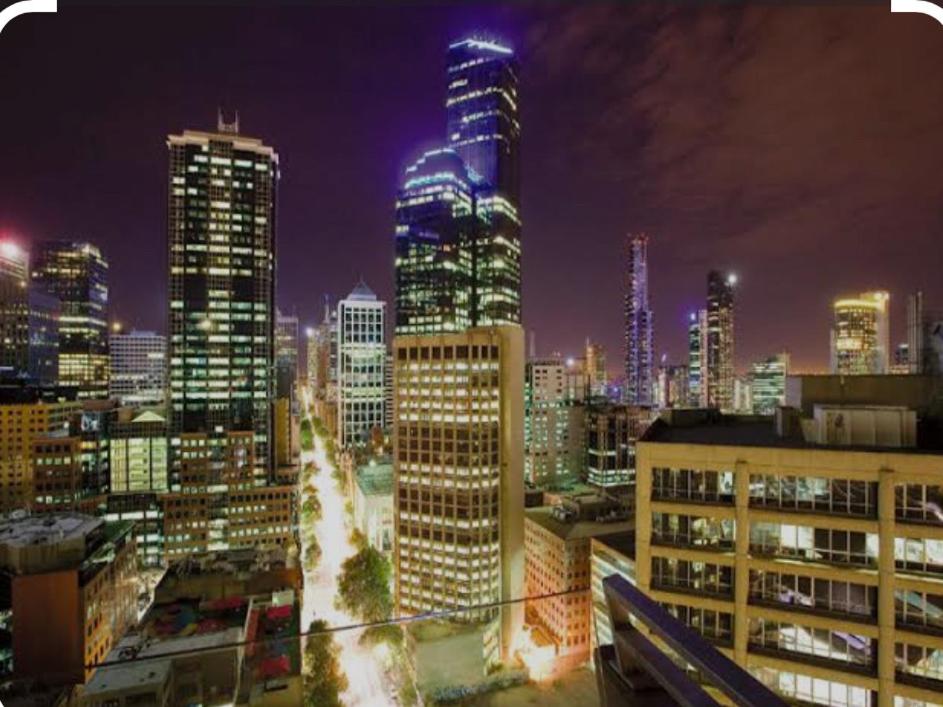 a view of a city skyline at night at Melborne Collins Home in Melbourne