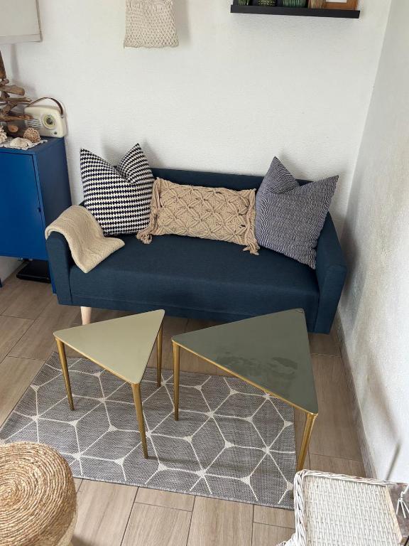 a living room with a blue couch and a table at Duplex plage des chalets Gruissan plage in Gruissan