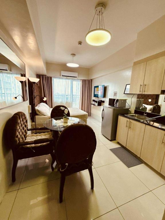 a kitchen and living room with a table and chairs at Breeze Staycation by Charmed in Manila