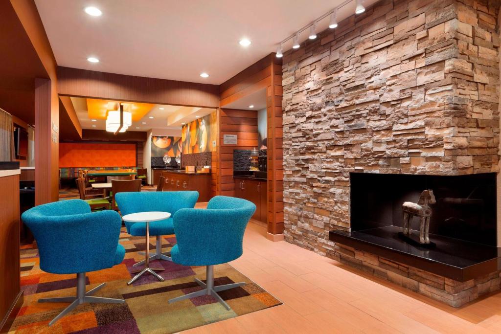 a lobby with blue chairs and a fireplace at Fairfield Inn & Suites Corpus Christi in Corpus Christi
